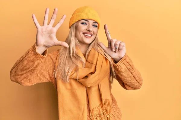 Ung Kaukasisk Kvinde Iført Uld Vinter Sweater Hætte Viser Peger - Stock-foto