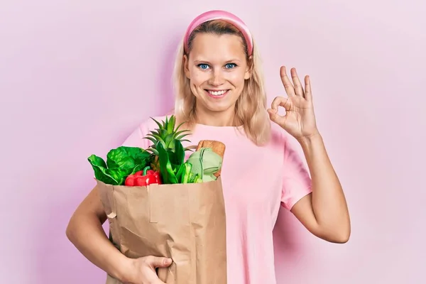 Schöne Kaukasische Blonde Frau Hält Papiertüte Mit Lebensmitteln Und Tut — Stockfoto