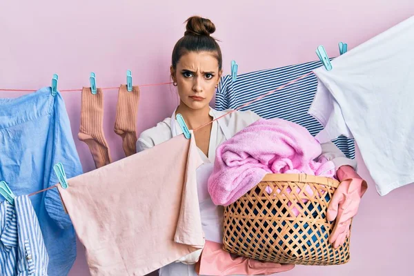 Beautiful Brunette Young Woman Holding Laundry Basket Skeptic Nervous Frowning — Stock Photo, Image