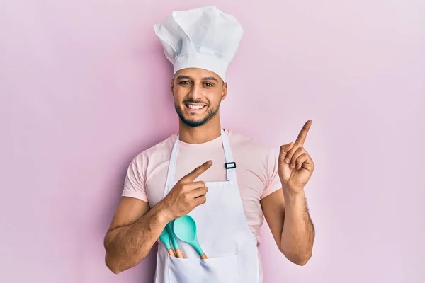 Hombre Árabe Joven Con Delantal Cocinero Profesional Sombrero Sonriendo Mirando —  Fotos de Stock