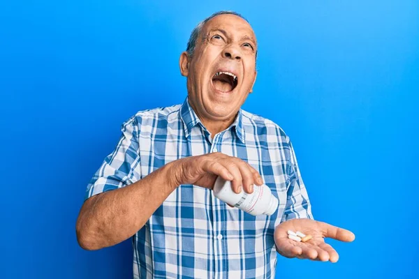 Hombre Hispano Mayor Sosteniendo Píldoras Enojado Loco Gritando Frustrado Furioso —  Fotos de Stock