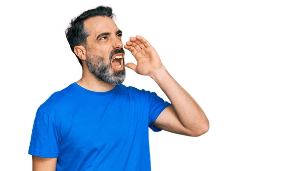 口の中で手で大声で叫んで大声で叫ぶカジュアルな青のTシャツを着てひげを持つ中年の男性 コミュニケーションの概念 — ストック写真