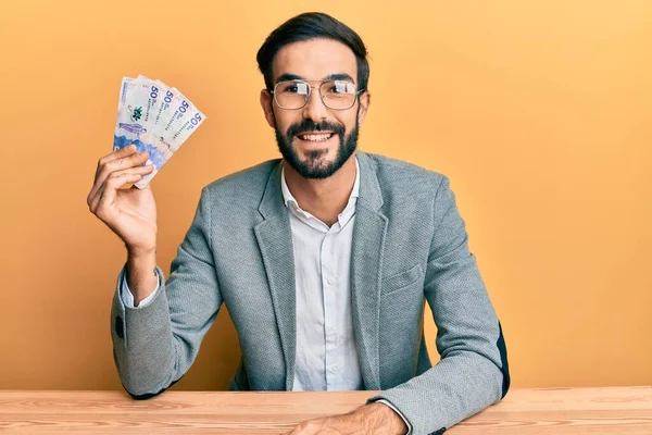 Fiatal Spanyol Férfi Kezében Kolumbiai Peso Bankjegyek Asztalon Pozitív Boldog — Stock Fotó