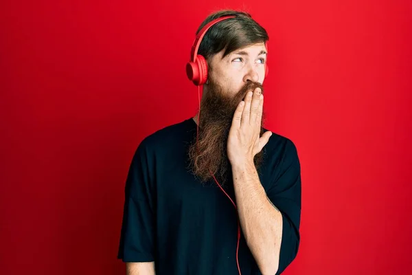 Kızıl Saçlı Uzun Sakallı Müzik Dinleyen Kulaklık Takan Ağzı Eliyle — Stok fotoğraf