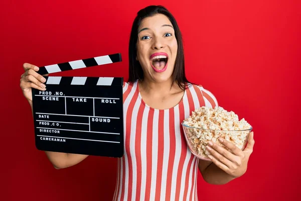 Młoda Latynoska Kobieta Trzyma Film Wideo Clapboard Popcorn Świętując Szaleństwo — Zdjęcie stockowe