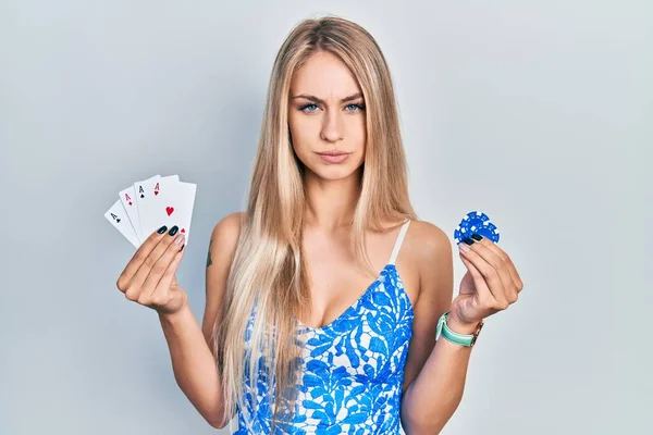 Elinde Poker Kartları Fişler Tutan Genç Beyaz Bir Kadın Şüpheci — Stok fotoğraf