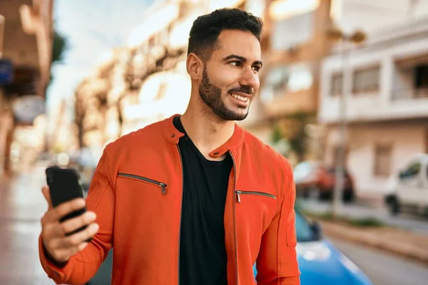 Ung Latinamerikansk Man Ler Glad Med Smartphone Stan — Stockfoto