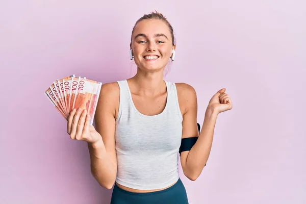 Beautiful Blonde Sport Woman Holding 100 Norwegian Krone Banknotes Screaming — Stock Photo, Image