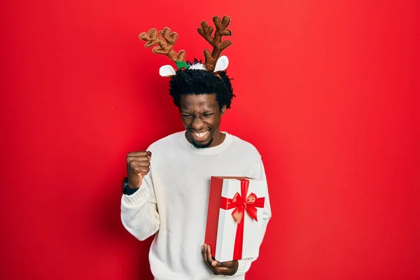Молодой Африканский Американец Рождественской Шляпе Оленя Держит Подарок Счастливый Взволнованный — стоковое фото