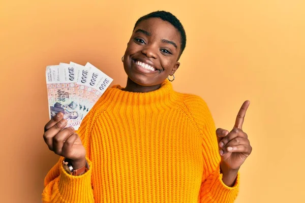 Mladá Africká Americká Žena Drží Icelandic Koruna Bankovky Úsměvem Šťastně — Stock fotografie