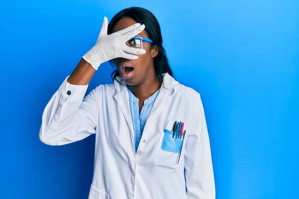 Mladá Afroameričanka Uniformě Vědkyně Vykukující Šoku Zakrývající Obličej Oči Rukou — Stock fotografie