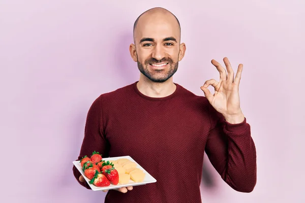 Young Bald Man Eating Fresh Healthy Fruits Doing Sign Fingers — Stock Photo, Image