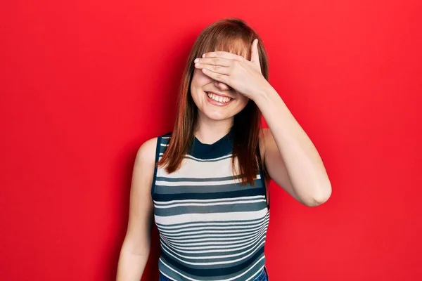カジュアルなTシャツを着た若い女性が笑顔で 驚きのために目を覆う顔で手で笑っています 視覚障害の概念 — ストック写真