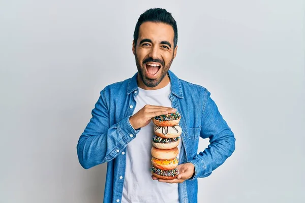 Jovem Hispânico Segurando Saborosos Donuts Coloridos Sorrindo Rindo Duro Voz — Fotografia de Stock