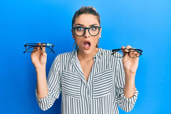 Mujer Joven Caucásica Sosteniendo Gafas Cara Choque Mirando Escéptico Sarcástico — Foto de Stock