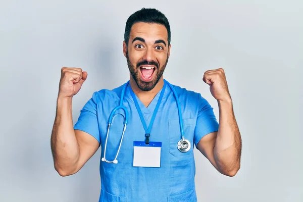 Bonito Homem Hispânico Com Barba Vestindo Uniforme Médico Gritando Orgulhoso — Fotografia de Stock