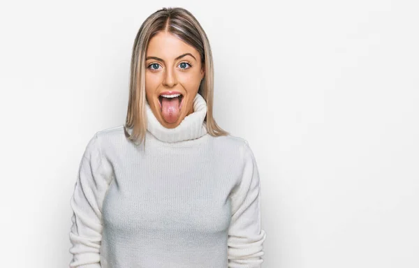 Piękna Blondynka Ubrana Luźny Sweter Wystający Języka Szczęśliwa Zabawnym Wyrazem — Zdjęcie stockowe