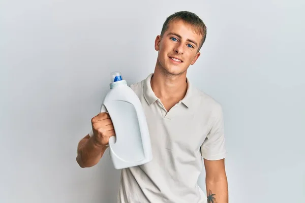 Jovem Caucasiano Segurando Garrafa Detergente Olhando Positivo Feliz Sorrindo Com — Fotografia de Stock