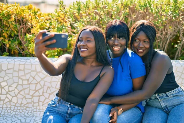 3人のアフリカ系アメリカ人の友人が公園でスマートフォンに笑顔で自撮り — ストック写真