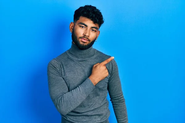 Hombre Árabe Con Barba Con Jersey Cuello Alto Apuntando Con — Foto de Stock