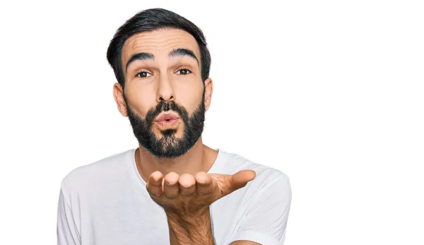 Joven Hombre Hispano Vistiendo Camiseta Blanca Casual Mirando Cámara Soplando — Foto de Stock