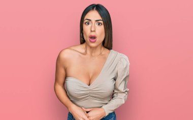 Gündelik kıyafetler giyen genç İspanyol kadın şaşkınlık, korku ve şaşkınlık dolu bir ifade içinde.. 