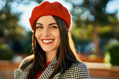 Genç İspanyol kadın gülümseyerek şehirde mutlu mesut dikiliyor..