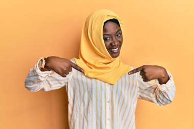 Geleneksel İslami başörtüsü takan güzel Afrikalı genç bir kadın. Kendine güvenen, yüzünde gülümseme olan, kendini gururlu ve mutlu gösteren bir eşarp.. 