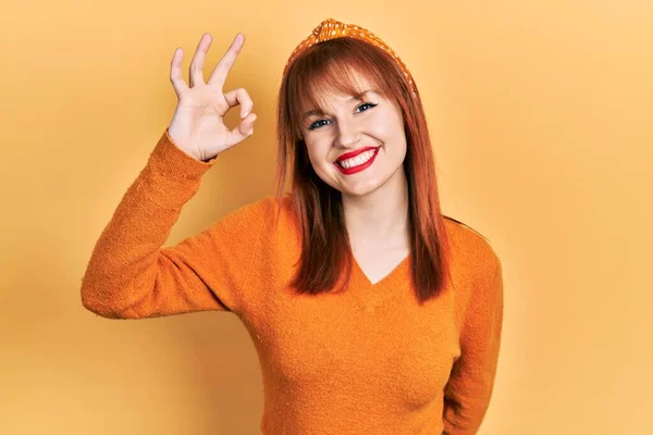 红头发的年轻女人穿着宽松的橙色毛衣 面带微笑 手指手画脚 成功表达 — 图库照片