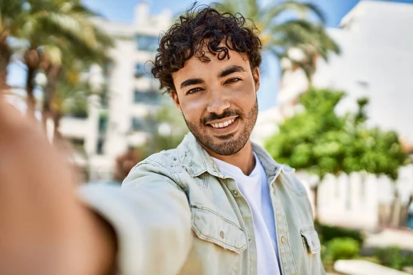 Yakışıklı, sakallı, güneşli bir günde mutlu bir şekilde gülümseyen bir İspanyol.