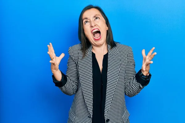 中年のヒスパニック系の女性がビジネス服を着て狂った叫びと積極的な表現と腕を上げて叫んでいた フラストレーションコンセプト — ストック写真