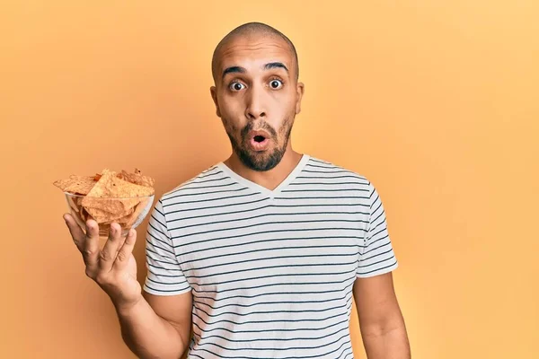 Hispanic Vuxen Man Håller Nachos Chips Rädd Och Förvånad Med — Stockfoto