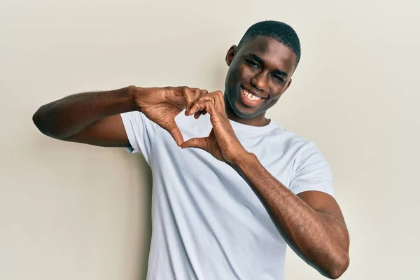 Молодой Африканский Американец Обычной Белой Футболке Улыбаясь Любви Показывает Символ — стоковое фото