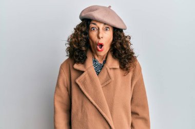 Orta yaşlı İspanyol kadın Fransız elbisesi giyiyor. Bere takmış. Korkmuş ve şok olmuş bir halde.. 