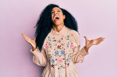 Orta yaşlı Afro-Amerikalı kadın gündelik kıyafetler giyip deli gibi bağırıyor ve agresif bir ifade ve kollarla bağırıyor. hüsran kavramı. 