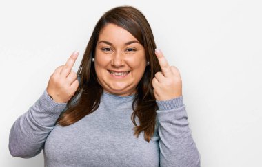 Beautiful brunette plus size woman wearing casual clothes showing middle finger doing fuck you bad expression, provocation and rude attitude. screaming excited 