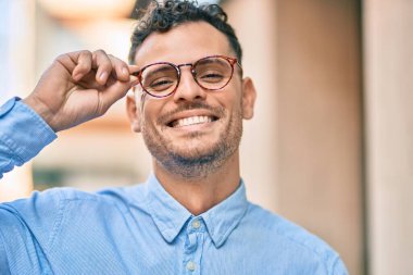 Genç İspanyol işadamı gülümseyerek şehirde bardaklarına dokunuyor..