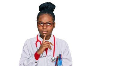 Genç Afro-Amerikan kadın doktor üniforması giyiyor ve steteskop düşüncesi şüpheye odaklanmıştı. 