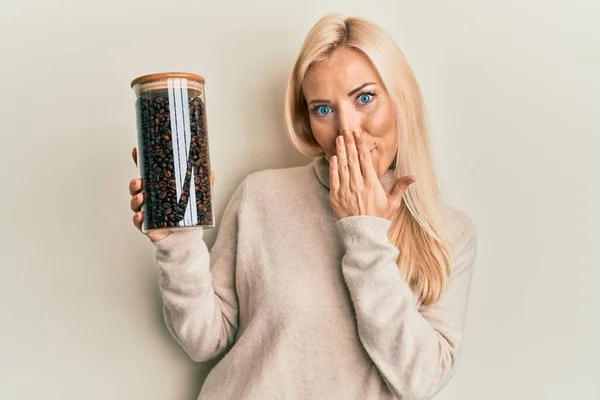 Ung Blond Kvinna Håller Burk Med Kaffebönor Täcker Munnen Med — Stockfoto