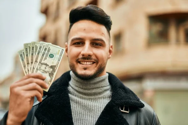 Joven Árabe Sonriendo Feliz Sosteniendo Dólares Ciudad —  Fotos de Stock