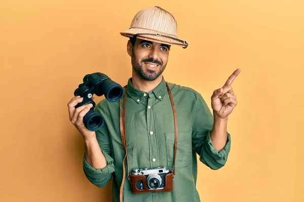 Young Hispanic Man Wearing Explorer Hat Looking Binoculars Smiling Happy — Stock Photo, Image