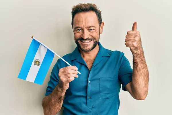 Hombre Mediana Edad Sosteniendo Bandera Argentina Sonriendo Feliz Positivo Pulgar — Foto de Stock
