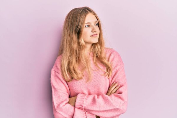 Красивая юная кавказская девушка в повседневной одежде смотрит в сторону со скрещенными руками убежденной и уверенной 