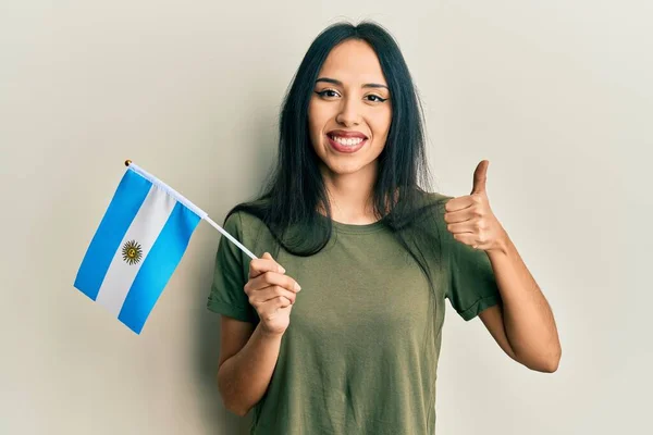 Menina Hispânica Jovem Segurando Bandeira Argentina Sorrindo Feliz Positivo Polegar — Fotografia de Stock