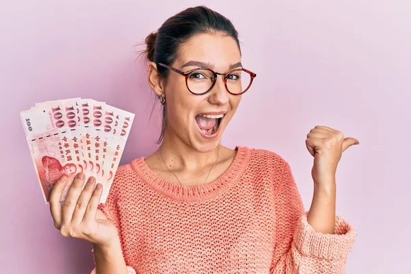 Joven Mujer Caucásica Sosteniendo 100 Nuevos Billetes Taiwan Dólares Apuntando —  Fotos de Stock