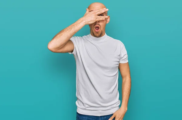 Hombre Calvo Con Barba Vistiendo Camiseta Blanca Casual Asomándose Shock —  Fotos de Stock