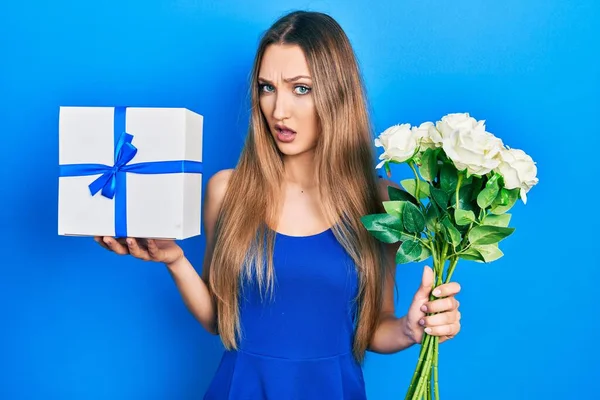 Chica Rubia Joven Sosteniendo Regalo Aniversario Ramo Flores Cara Choque — Foto de Stock