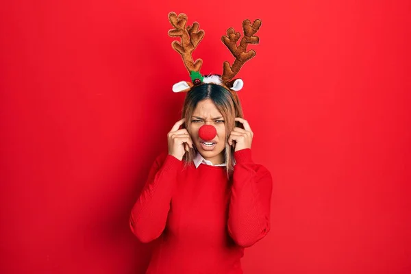 크리스마스 모자를 시끄러운 소리에 짜증나는 표정으로 손가락으로 아름다운 스페인 — 스톡 사진