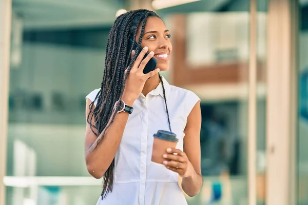 若いアフリカ系アメリカ人の女性がスマートフォンで話して街でコーヒーを飲んで — ストック写真