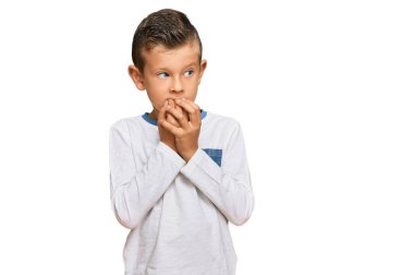 Günlük kıyafetler giyen sevimli beyaz çocuk gergin ve gergin görünüyor. Ağzı tırnak yiyen ellerle. anksiyete. 